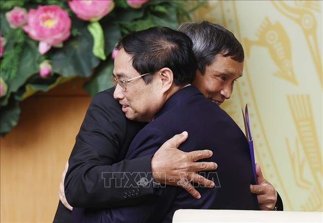 Thủ tướng Phạm Minh Chính chúc mừng Huấn luyện viên Mai Đức Chung. Ảnh: Dương Giang/TTXVN