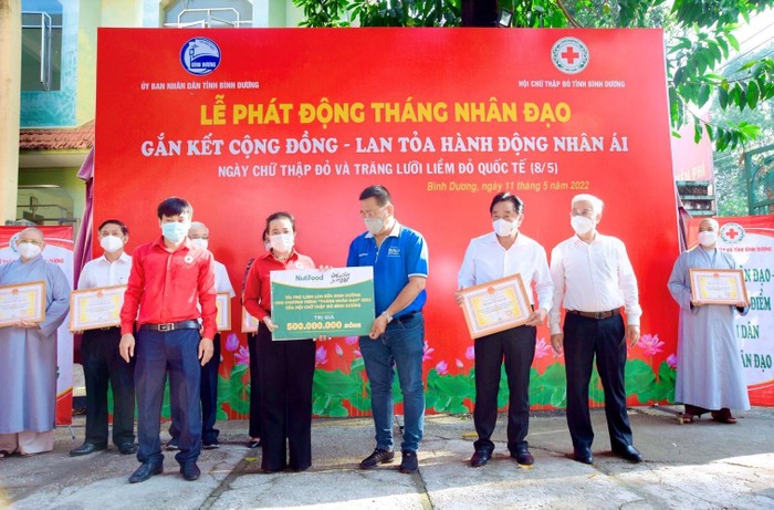 Đại diện Công ty CP Thực phẩm Dinh dưỡng Nutifood trao bảng tượng trưng hỗ trợ hàng ngàn phần quà dinh dưỡng trị giá 500 triệu đồng cho Hội Chữ thập đỏ tỉnh Bình Dương