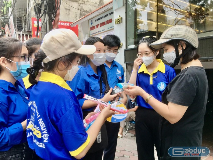 Đội tình nguyện tại điểm Trường Trung học phổ thông Quang Trung – Đống Đa (quận Đống Đa, Hà Nội) cấp phát nước miễn phí cho phụ huynh học sinh. (Ảnh: Ngọc Mai).