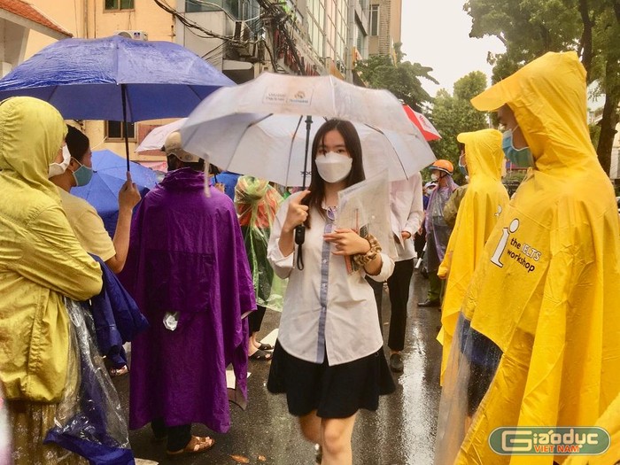 Đội tình nguyện tại điểm Trường Trung học phổ thông Quang Trung – Đống Đa (quận Đống Đa, Hà Nội) đội mưa hỗ trợ thí sinh trong buổi thi buổi chiều. (Ảnh: Ngọc Mai).