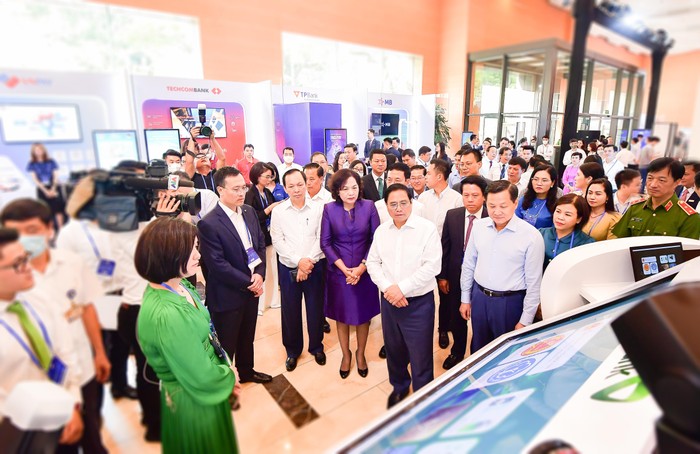 Ban Lãnh đạo Vietcombank giới thiệu về sản phẩm dịch vụ của Vietcombank với đoàn đại biểu do Thủ tướng Chính Phủ Phạm Minh Chính (hàng đầu thứ hai từ phải sang) dẫn đầu tại sự kiện. Ảnh: Duy Thanh