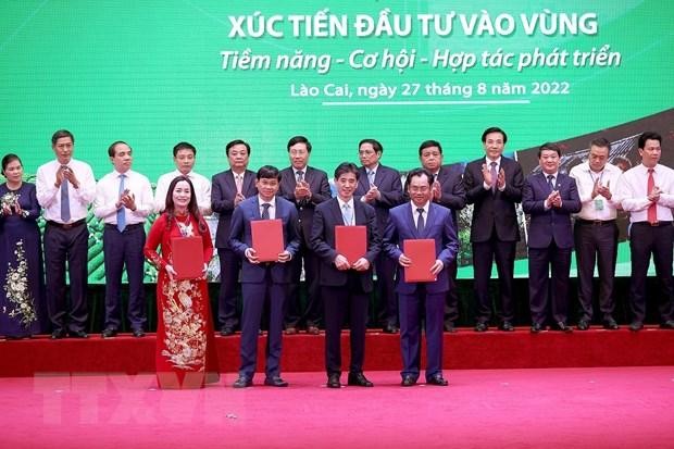 Thủ tướng Phạm Minh Chính và các đại biểu chứng kiến trao thoả thuận hợp tác đầu tư, bản ghi nhớ và chứng nhận đầu tư của các địa phương trong vùng. (Ảnh: Dương Giang/TTXVN)
