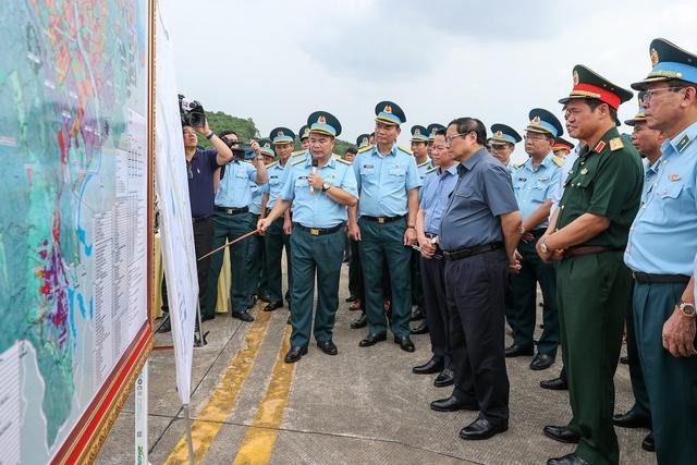 Thủ tướng nghe các đơn vị liên quan báo cáo khi khảo sát thực địa sân bay Yên Bái. Ảnh: VGP/Nhật Bắc