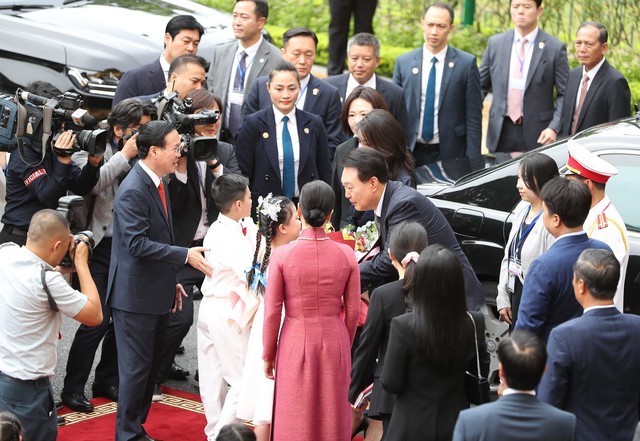 Học sinh Hà Nội tặng hoa Tổng thống Hàn Quốc và phu nhân. Ảnh: VGP
