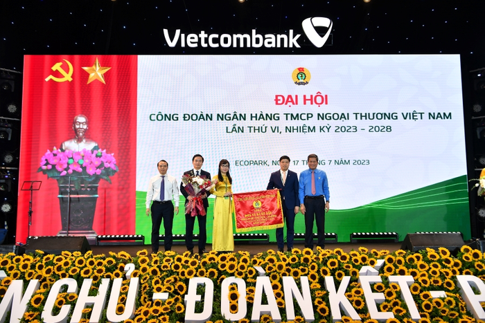 Đồng chí Huỳnh Thanh Xuân – Phó Chủ tịch Tổng Liên đoàn Lao động Việt Nam (ngoài cùng bên phải) tặng Cờ Thi đua của Tổng Liên đoàn Lao động Việt Nam và đồng chí Đỗ Việt Hùng – Phó Bí thư thường trực Đảng ủy Vietcombank (ngoài cùng bên trái) tặng hoa cho đại diện Công đoàn Vietcombank.