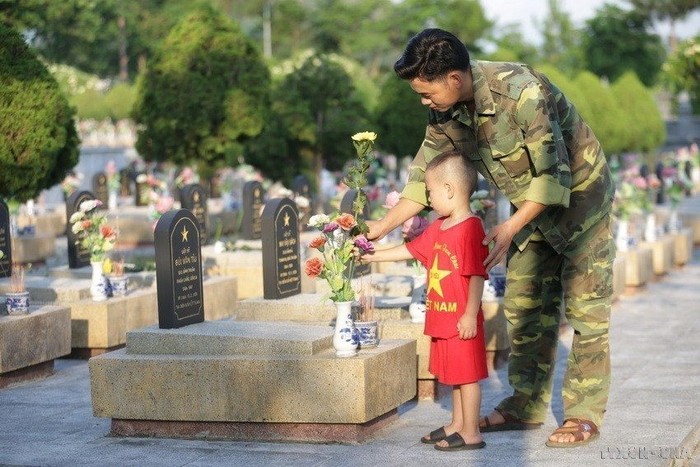 Hai cha con dâng hoa, thắp hương lên mộ liệt sỹ tại Nghĩa trang liệt sỹ tỉnh Lai Châu. Đây là nơi an nghỉ của các anh hùng liệt sĩ qua các thời kỳ. (Ảnh: Anh Tuấn/TTXVN)
