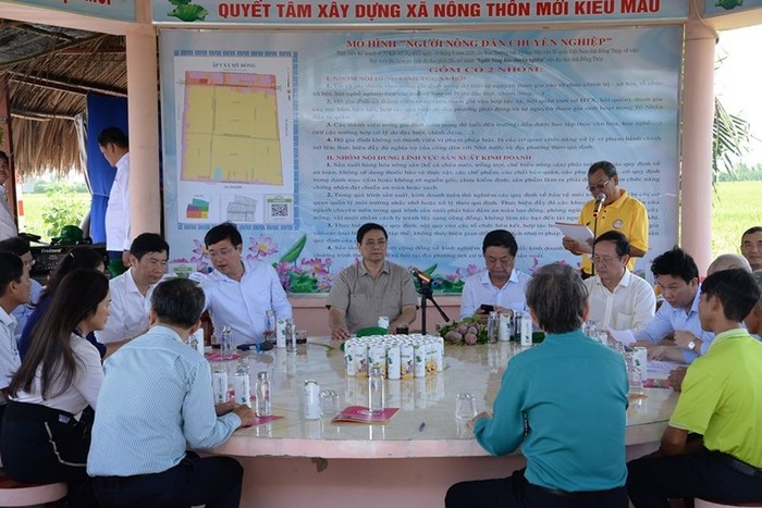 Thủ tướng Phạm Minh Chính nghe lãnh đạo Hợp tác xã Dịch vụ nông nghiệp Thắng Lợi giới thiệu về cánh đồng lúa canh tác theo mô hình công nghệ cao.
