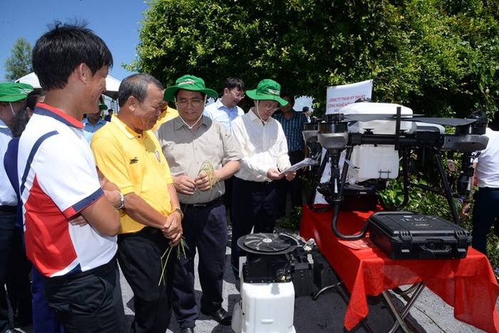 Thủ tướng Phạm Minh Chính nghe giới thiệu về thiết bị bay không người lái phun thuốc trừ sâu tại cánh đồng lúa canh tác theo mô hình công nghệ cao.