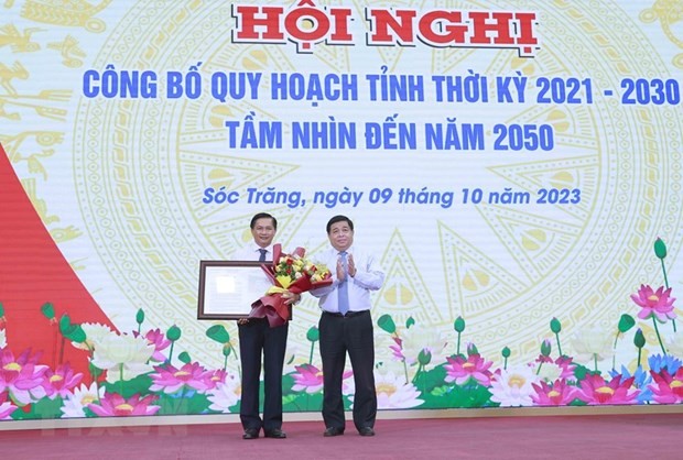 Bộ trưởng Bộ Kế hoạch và Đầu tư Nguyễn Chí Dũng trao Quyết định của Thủ tướng Chính phủ phê duyệt Quy hoạch tỉnh Sóc Trăng thời kỳ 2021-2030, tầm nhìn đến năm 2050. (Ảnh: Doãn Tấn/TTXVN)