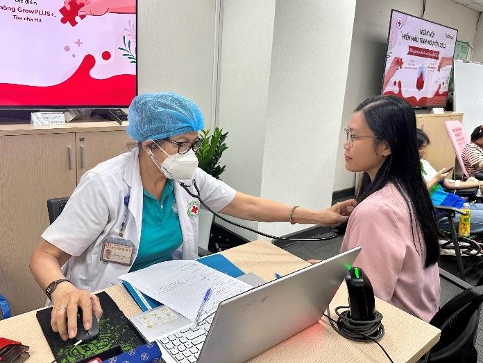A doctor checking a patient's blood pressure Description automatically generated