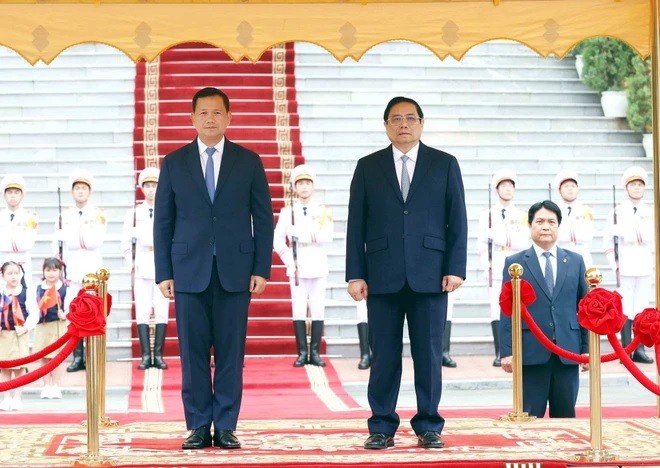 Thủ tướng Phạm Minh Chính và Thủ tướng Campuchia Samdech Hun Manet nghe quân nhạc cử Quốc thiều hai nước. (Ảnh: Dương Giang/TTXVN)