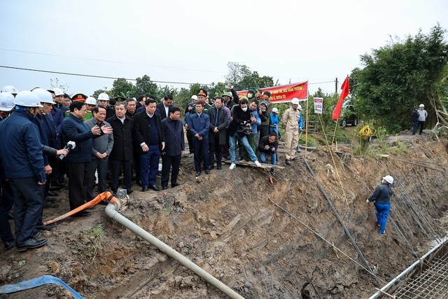 Thủ tướng Phạm Minh Chính và đoàn công tác thị sát công trình thi công móng cột vị trí 201 trên địa bàn xã Châu Sơn, huyện Quỳnh Phụ, Thái Bình. Ảnh: VGP/Nhật Bắc