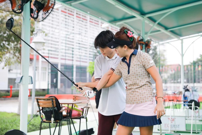 Huấn luyện viên trưởng bộ môn golf của EQuest NGô Bảo Nghi đang hướng dẫn học sinh kĩ thuật golf