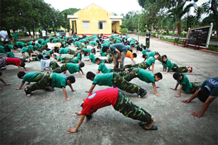 Các em học sinh đang luyện tập thể dục, thể thao trong kỳ học quân đội