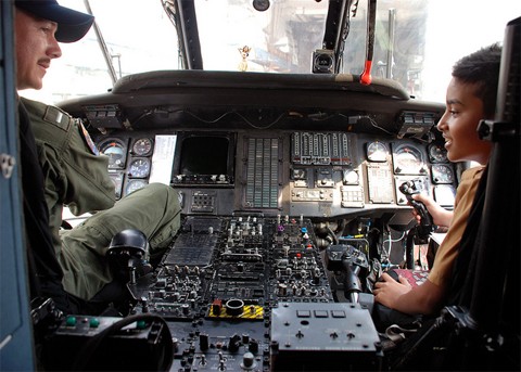 Phi công trên máy bay chống tàu ngầm hướng dẫn cho một em bé Indonesia các kỹ thuật bay. Ảnh: US Navy