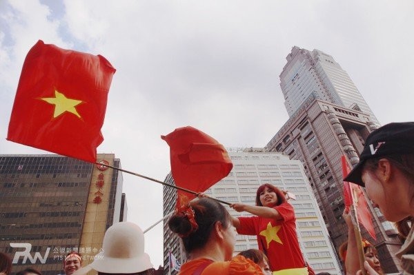 Một phụ nữ Việt ở Đài Loan giương cao cờ đỏ sao vàng trong cuộc tuần hành yêu cầu Trung Quốc rút giàn khoan 981 ra khỏi vùng đặc quyền kinh tế, thềm lục địa của Việt Nam.