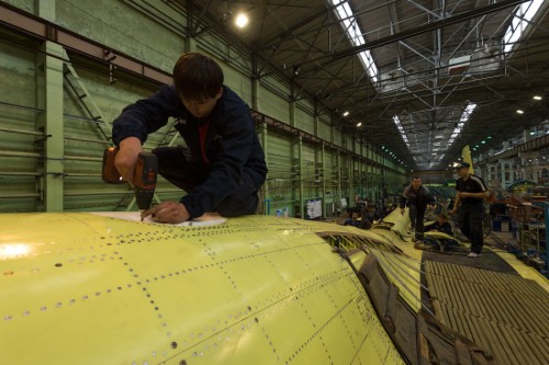 Công nhân dùng máy khoan điện lắp đinh tán cho máy bay Su-34 Nga