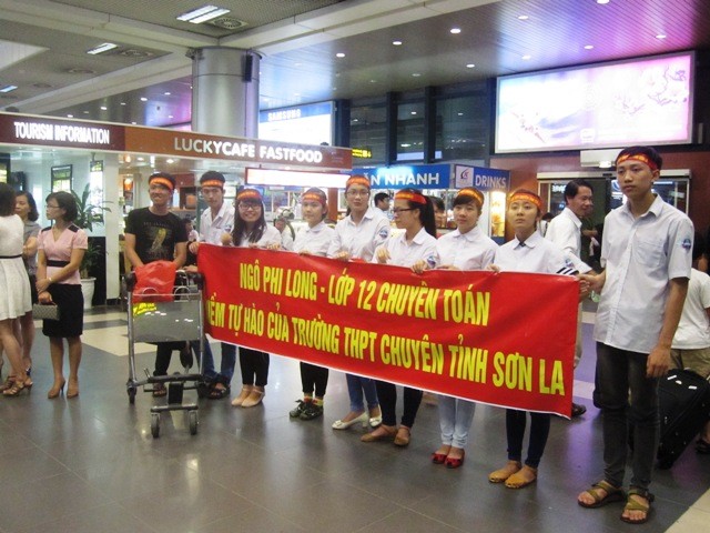 Bạn bè ôm hoa, băng rôn chào đón các thành viên đội tuyển Olympic Vật lí trở về từ Indonesia. Ảnh Xuân Trung