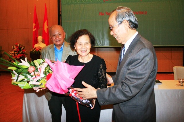 Chủ tịch Hiệp hội các trường ĐH, CĐ NCL Trần Hồng Quân tặng hoa chúc mừng các hội viên. Ảnh Xuân Trung