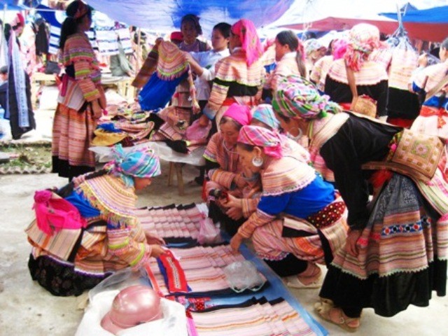 Người dân tộc Mông đi chợ mua vải về may quần áo