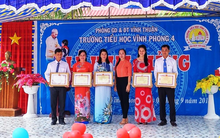 Từ trái sang: Thầy Nguyễn Đô Rin, cô Trịnh Ngọc Thuỳ Mai - Hiệu trưởng (thứ 2 từ trái sang), cô Đặng Thị Nhi, đại biểu trao danh hiệu Đặng Thị Hồng Nhiên – Bí thư xã Đoàn xã Vĩnh Phong, cô Võ Thị Mỹ Ly và thầy Trần Quốc Khoa. (Ảnh: c1vinhphong4.vinhthuan.edu.vn).