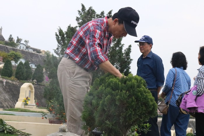 Con cháu trong gia đình chăm sóc mộ phần gia tiên. Ảnh: Đỗ Thơm