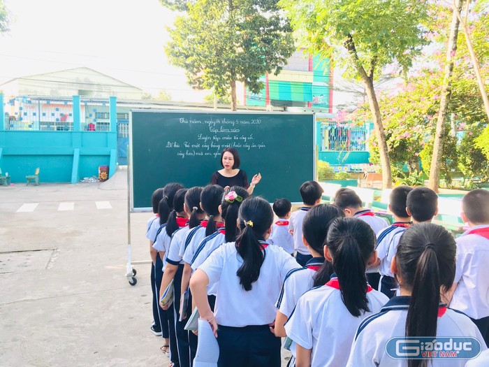 Các em học sinh trường tiểu học Phú Hòa 3 đang hoc môm tập làm văn ở ngoài công viên trường.