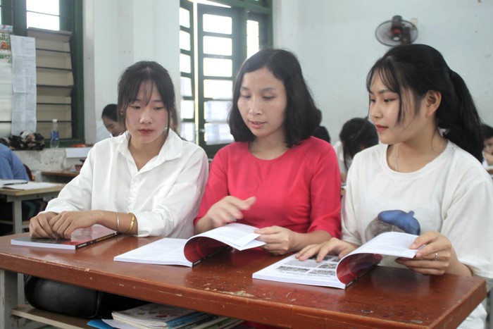 Cô giáo Nguyễn Thị Ngọc Hà hướng dẫn học sinh 12 sử dụng cuốn sách ôn thi tốt nghiệp Trung học phổ thông qua thơ.