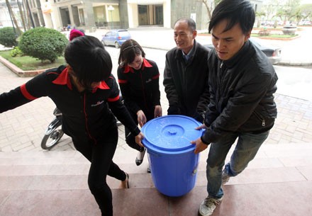 Nhân viên một nhà hàng tại khu Trung Hòa được huy động đi xách nước