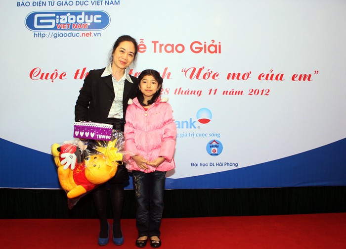 Bà Nguyễn Thị Minh Thu chụp ảnh lên báo trong một chương trình do báo Giáo dục Việt Nam tài trợ ở Lớp học Hy vọng