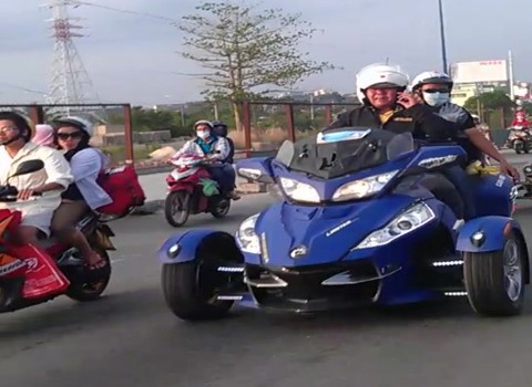 Một người vừa điều khiển chiếc xe Can - Am Spyder vừa nghe điện thoại.