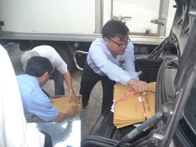 Đại diện các trường ĐH tại TPHCM nhận bài thi và chuyển các túi bài thi lên xe để đưa về trường chấm thi. Ảnh: Quang Phương.