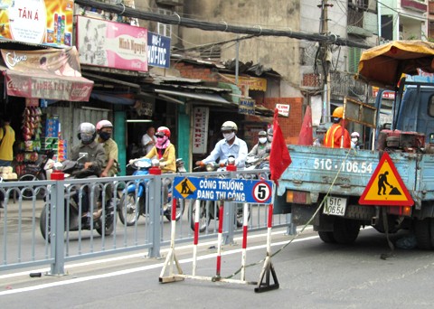 Công nhân đang thi công lắp đặt dải phân cách thép tim đường trên đường Xô Viết Nghệ Tĩnh, quận Bình Thạnh. Ảnh: H.C.