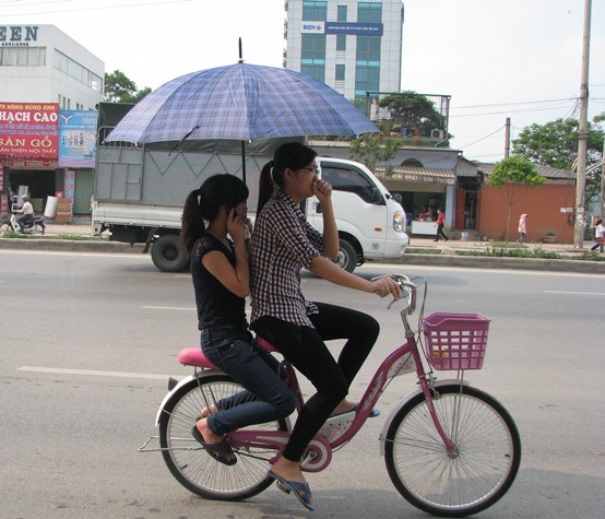 Vừa che ô, vừa nghe điện thoại khi tham gia giao thông trên đường.