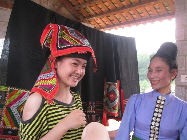 Bạn Nguyễn Thị Thủy thích thú khi được đội chiếc khăn Piêu của dân tộc Thái (tỉnh Sơn La).
