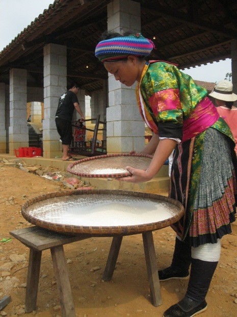 Thiếu nữ dân tộc Mông (tỉnh Hà Giang) sàng bột ngô để nấu mèn mén là món ăn đặc trưng của địa phương.