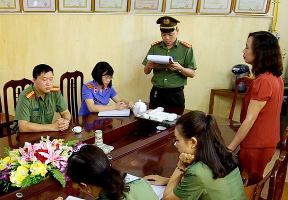 Công an đọc lệnh khởi tố bị can đối với Triệu Thị Chính, nguyên Phó giám đốc Sở Giáo dục và Đào tạo Hà Giang. (Ảnh: Công an nhân dân)