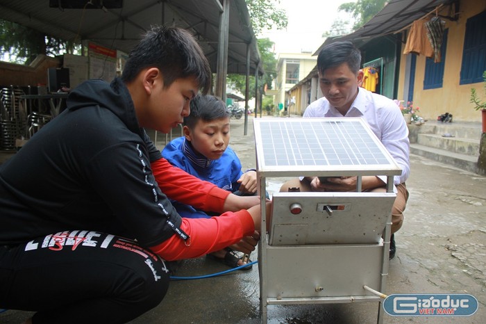 Thầy trò Hoàng Văn Mạo cùng hoàn thiện hệ thống tưới nước phun sương tự động (Ảnh: Nguyễn Toan)