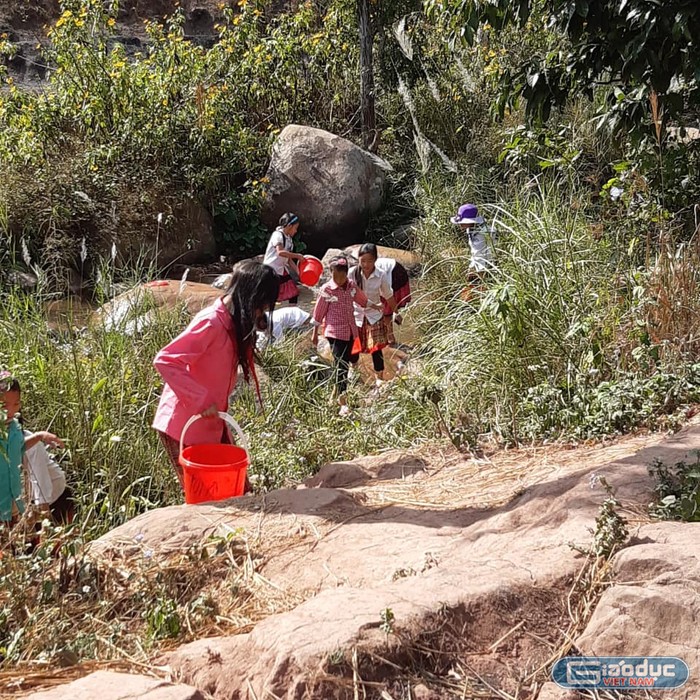 Sau giờ học, học sinh ở Na Cô Sa phải đi tìm đến những khe nước ở tận trong những khe đá sâu trong núi. Ảnh: LC