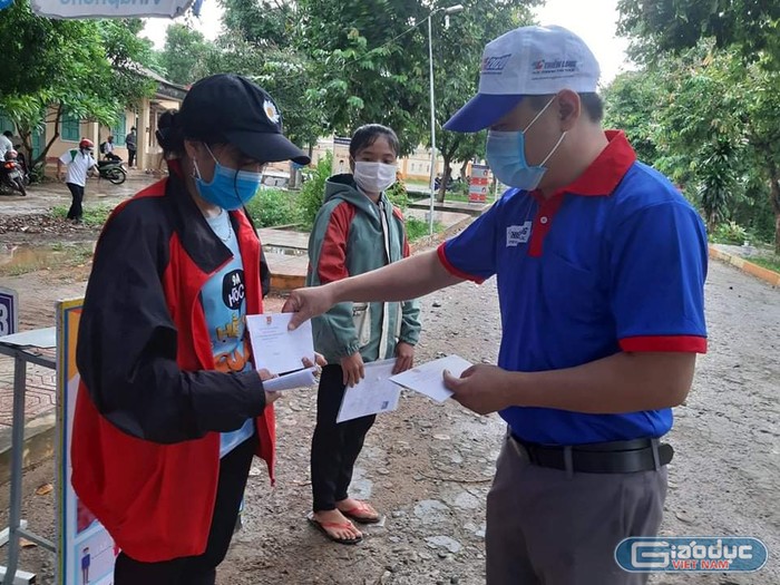 Thầy Lê Chí Thông phát phần quà của các nhà hảo tâm đến các bạn học sinh khó khăn.