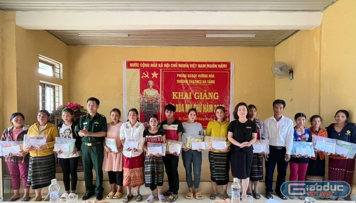 Cô giáo Phạm Thanh Nga - Trưởng phòng Giáo dục và Đào tạo Hướng Hóa (thứ 6 từ phải qua) cùng Thiếu tá Hồ Văn Hai, Đội trưởng kiểm soát hành chính, Đồn Biên phòng Ba Tầng và lãnh đạo địa phương trao đồ dùng học tập cho các học viên lớp xóa mù. Ảnh: Ngọc Hiển