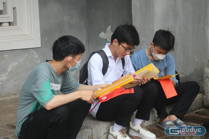 Nhóm học sinh Trường trung học phổ thông Hồng Thái, Đan Phượng chăm chú thảo luận, viết sớ cầu cho mình hoàn thành tốt kỳ thi tốt nghiệp trung học phổ thông.