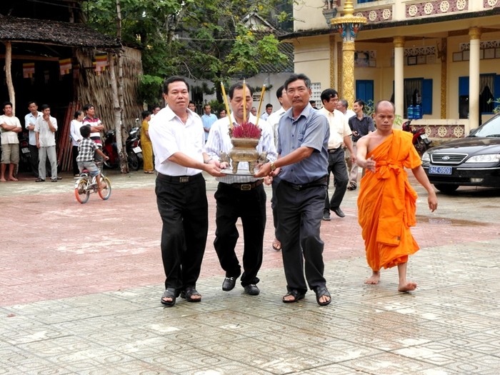 Ông Trầm Bê bưng bát hương tiến ra sân.