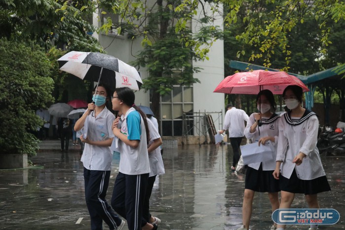 Sát giờ thi môn Toán, cơn mưa to bất ngờ trút xuống khiến các sĩ tử và phụ huynh vất vả hơn khi di chuyển tới các điểm thi. Ảnh: Doãn Nhàn