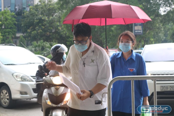 Nhiều tình nguyện viên di chuyển ra tận đầu đường để đón các thí sinh vào phòng thi. Ảnh: Doãn Nhàn