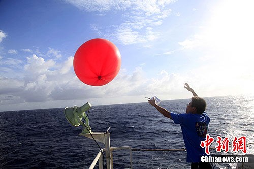 Nhân viên trên tàu "Thực nghiệm 3" Trung Quốc thả bóng bay chào quân Trung Quốc đồn trú trên Đá Chữ Thập