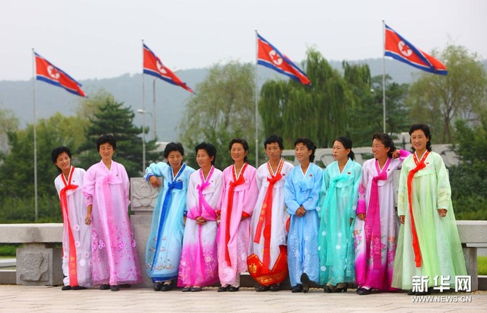 Phụ nữ Bắc Triều Tiên trong trang phục truyền thống, điểm khác biệt duy nhất với phụ nữ Hàn Quốc là có thêm huy hiệu lãnh tụ trên ngực áo