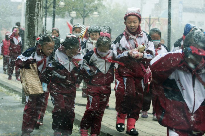 Học sinh Bắc Kinh đến trường trong trận mưa tuyết đầu mùa
