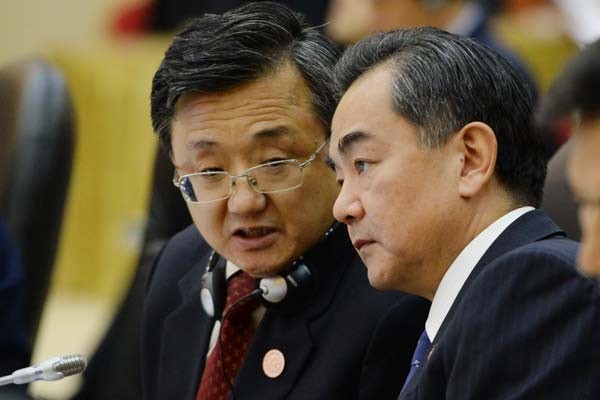 Ông Vương Nghị, Ngoại trưởng Trung Quốc (phải) đang nghe một thành viên trong đoàn báo cáo khi tham dự Hội nghị Ngoại trưởng ASEAN tại Brunei
