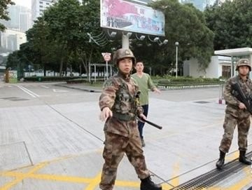 Lính vệ binh ngoài Bộ Tư lệnh quân sự Trung Quốc tại Hồng Kông ngăn nhóm người biểu tình xông vào trụ sở.